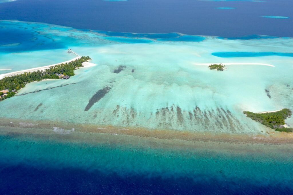 Explore the serene beauty of Maldives islands with crystal-clear turquoise waters from an aerial perspective.